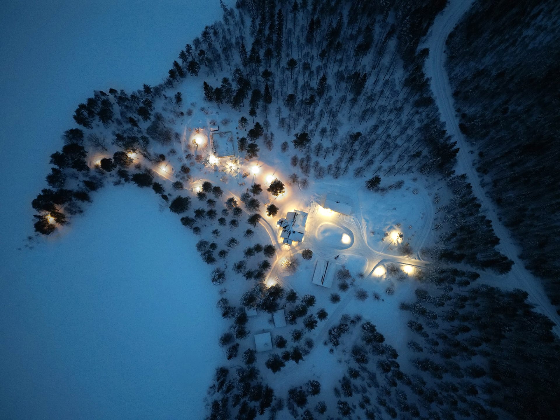 A bird’s-eye view of Villa Cone Beach and across the snowy Lake Korpijärvi into the wilderness, showcasing the place