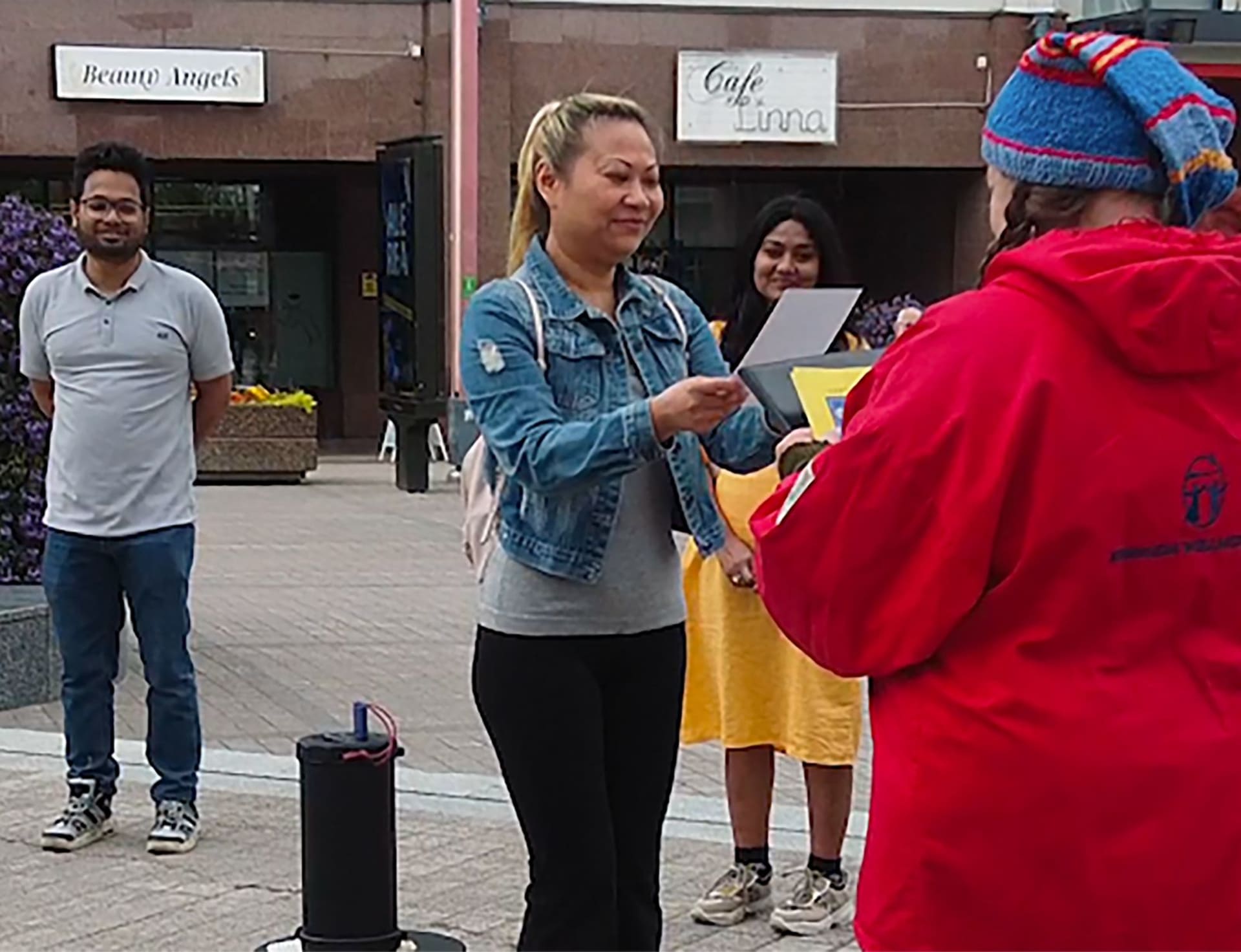 Happy lady receiving a certificate from the Good Will Elf at the Lordi square.