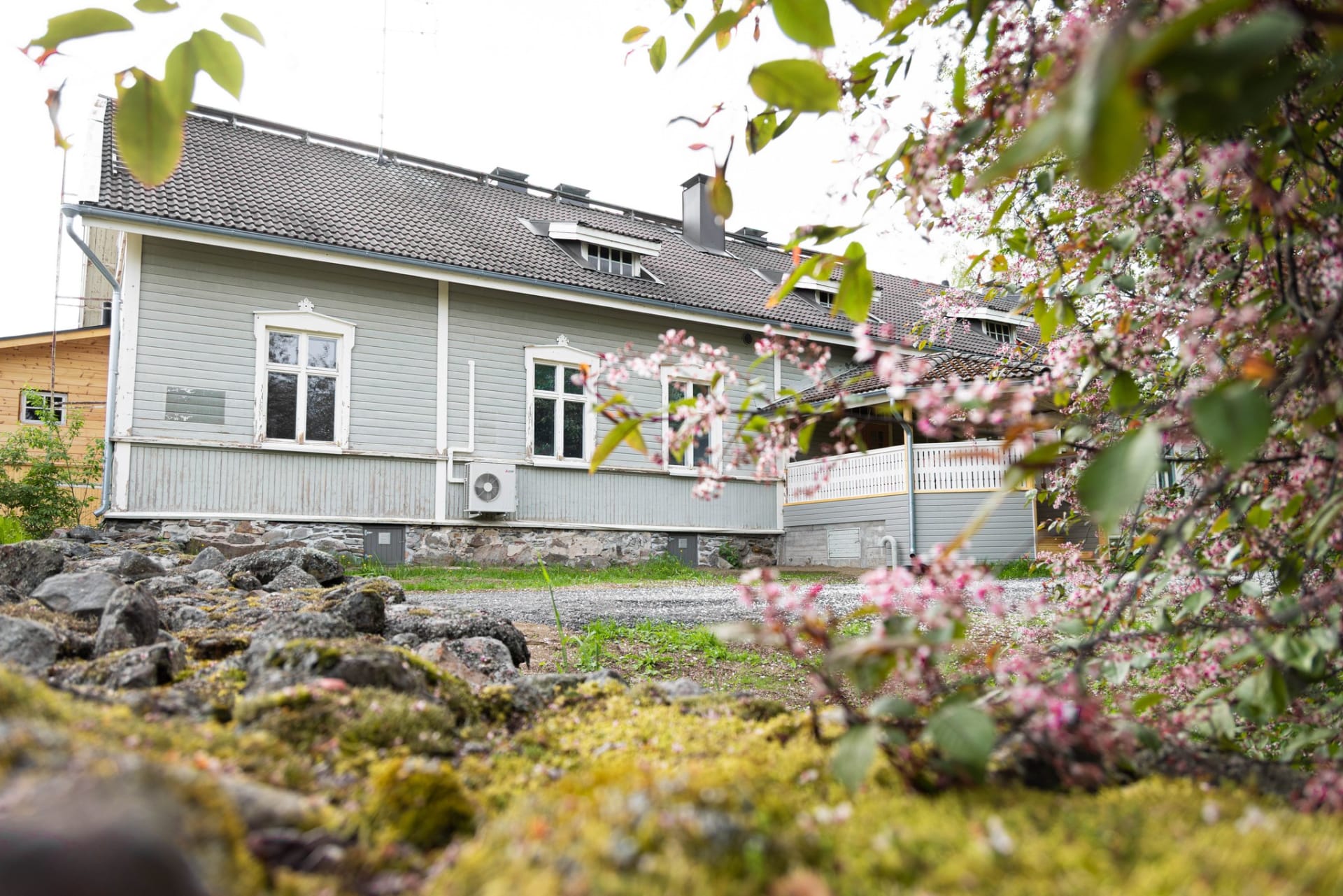 Puinen, vanha ja perinteikäs rakennus, jossa on neliosaisia pystyikkunoita sekä kuisti ulko-oven edustalla. 