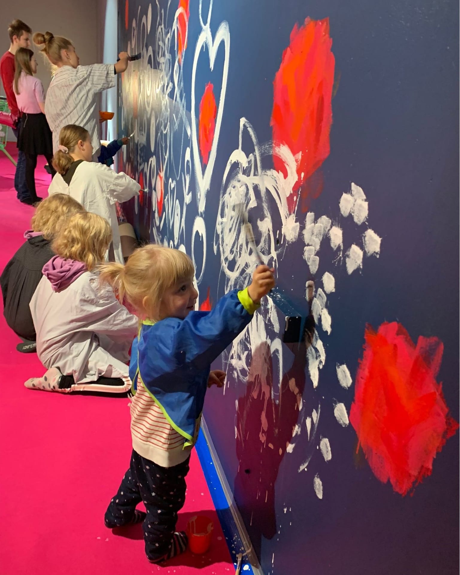 Lapset maalaamassa suttuja seinään