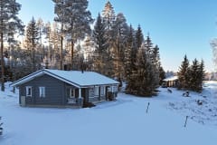 Lomamökki ja pihapiiri talvella auringonpaisteessa