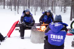Men grilling sausages outdoors in winter