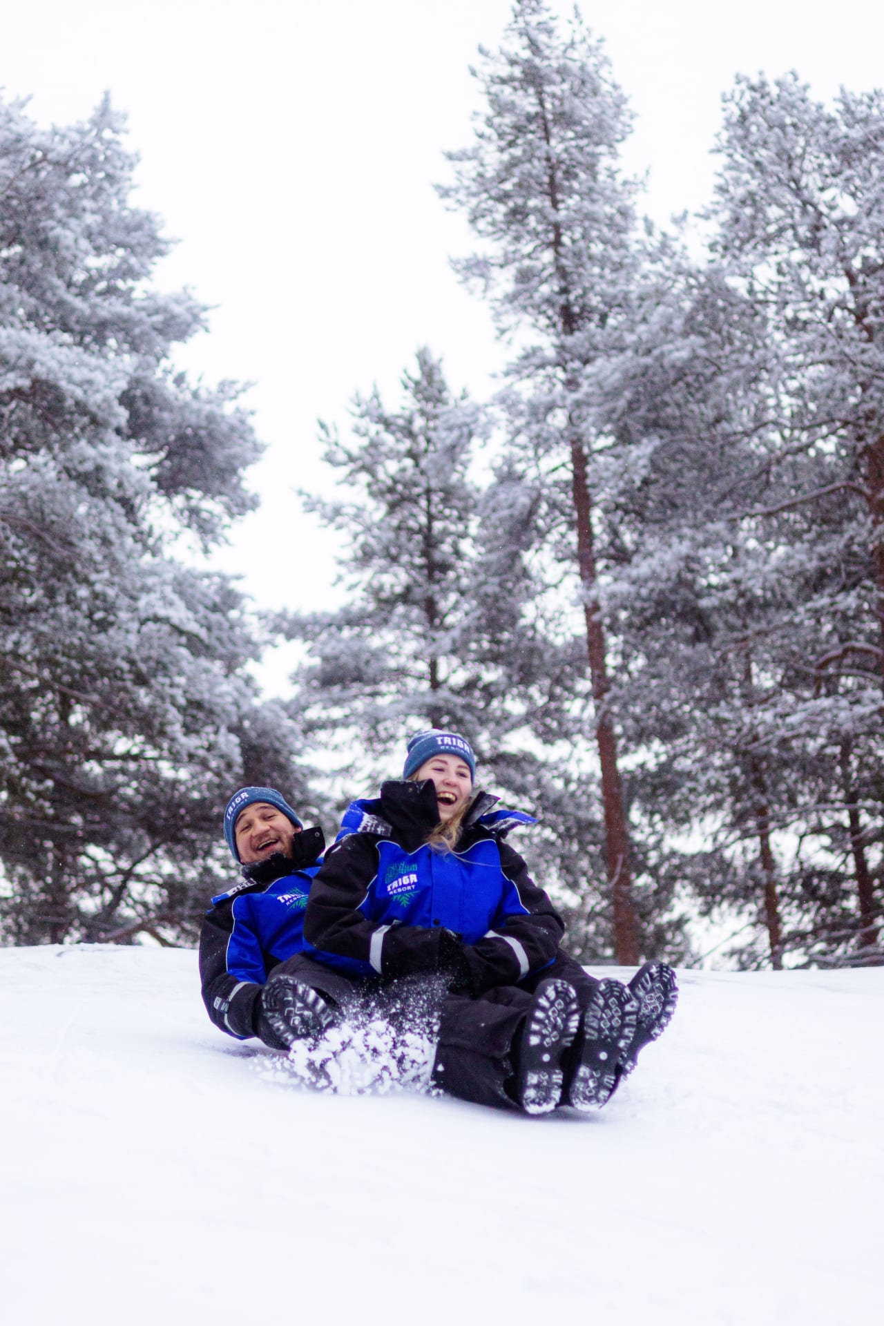 a couple having fun sledding in winter time