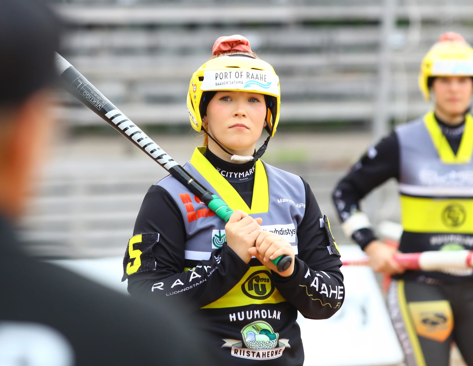 Pesäpalloilija lyöntipaikalla maila olalla.