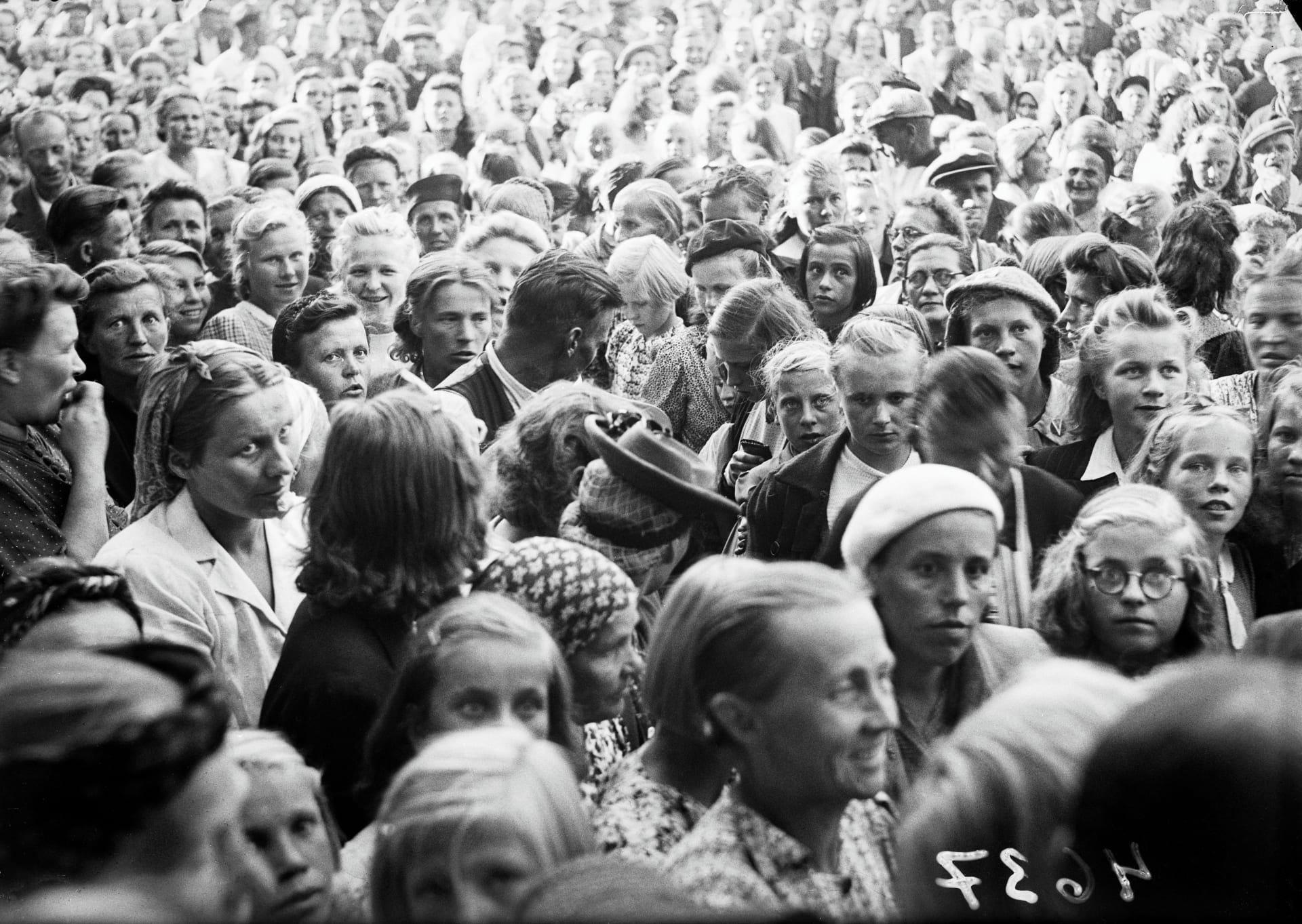 Vanha mustavalkoinen kuva suuresta ihmisjoukosta, kuvattu ylhäältä päin.
