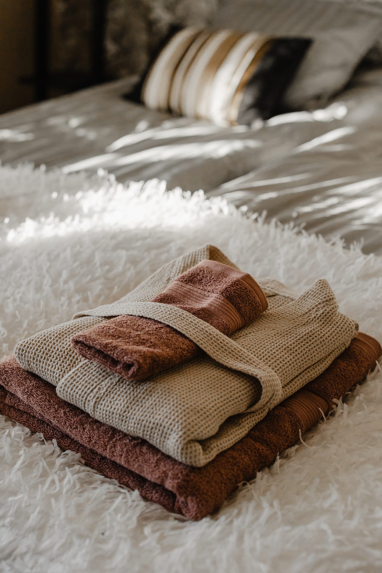 Luxurious bath rope and towels beautifully set on a bed to wait for the guests at the accomodation