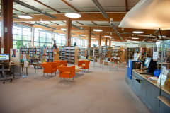 kirjastorakennus sisäpuolelta: kirjahyllyjä ja tuoleja