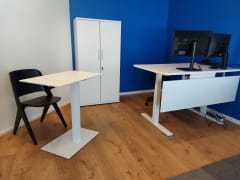 Kaksi säädettävää työpistettä ja kaappi sekä työtuoli