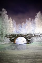 Winter view of the bridge, frozen river and frosty trees