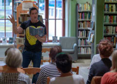 a man having a reading to an audience at a library
