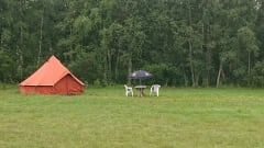 Glamping in Hailuoto. Outdoor chairs and table next to tent.