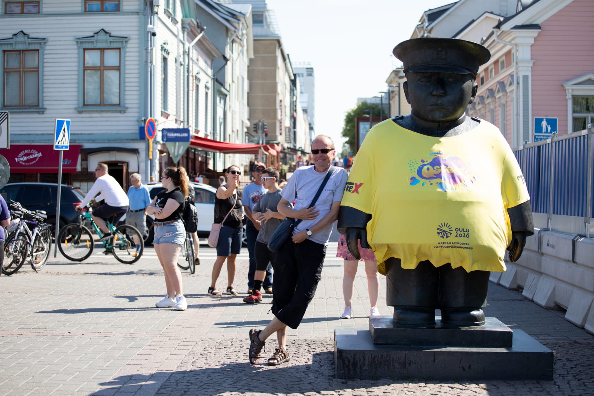 Market square policeman with yellow Qstock t-shirt.