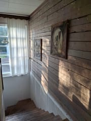 Majatalo on sisustettu tunnelmallisesti. Kuvassa rouheaa lautaseinää portaikossa.