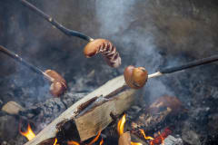Sausage grilling at campfire in Rantakylä.