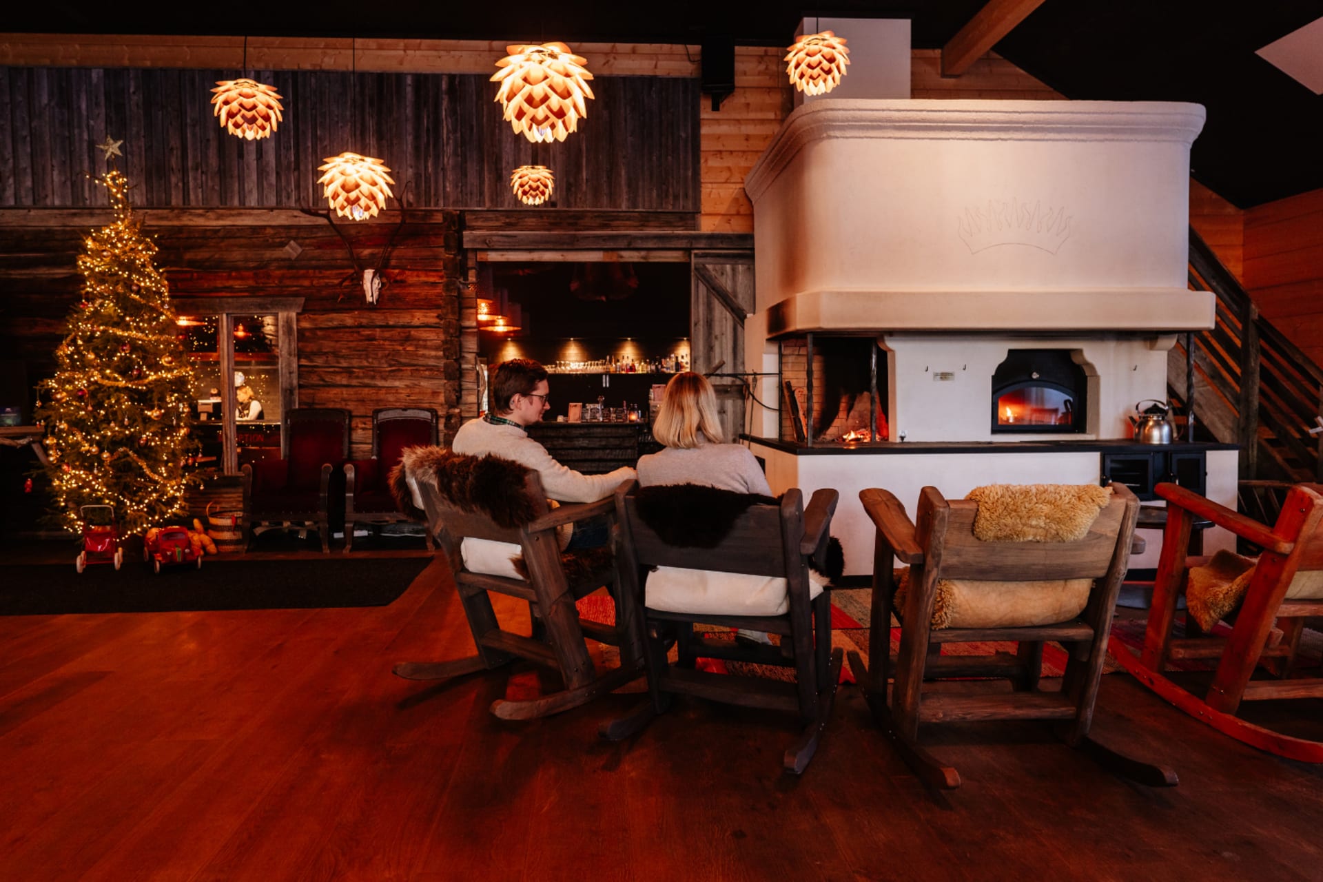 A couple haveing a good time by the massive fireplace of Restaurant Aitta in Apukka Resort Rovaniemi Lapland Finland 