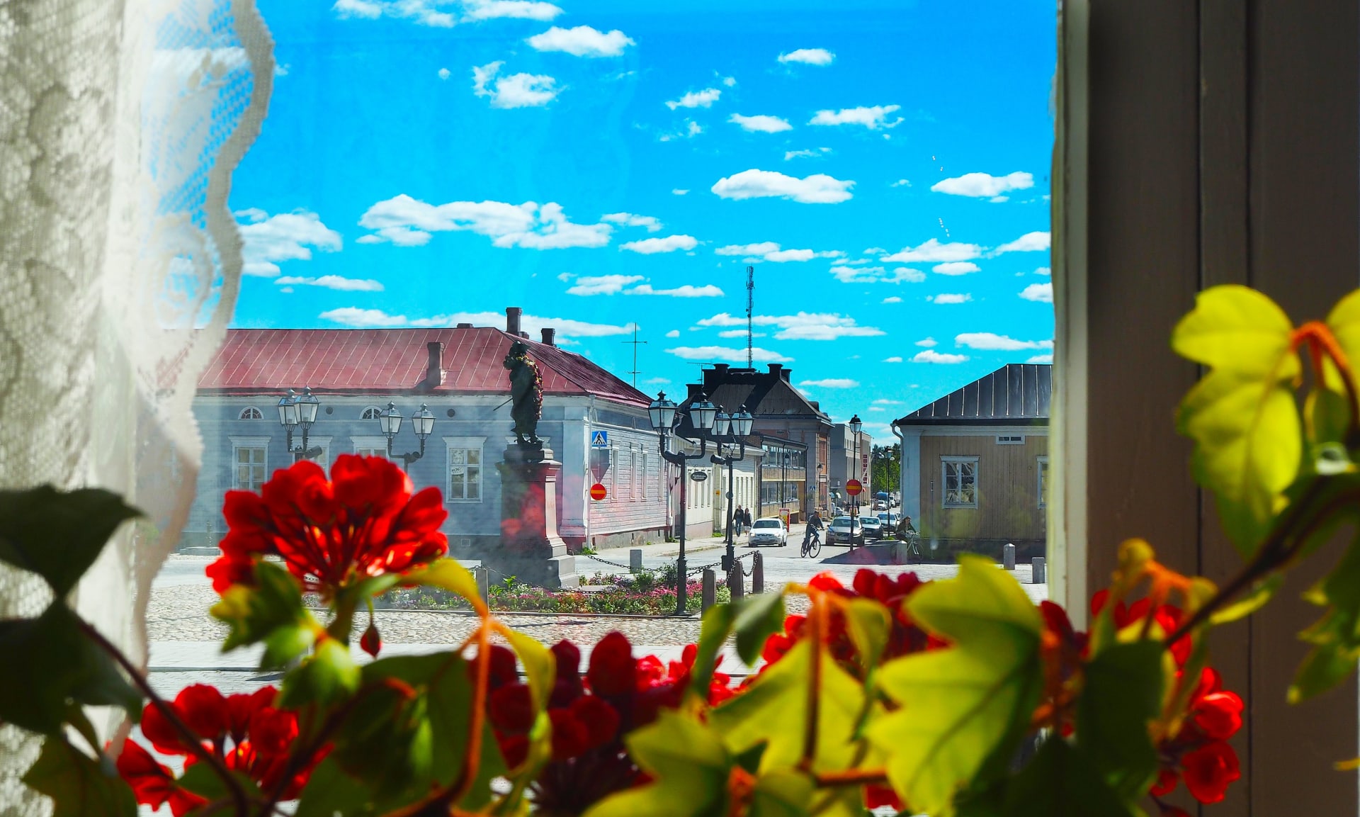 Pekkatori square in old town raahe through a window with flowers