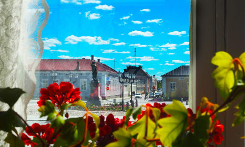 Pekkatori square in old town raahe through a window with flowers  