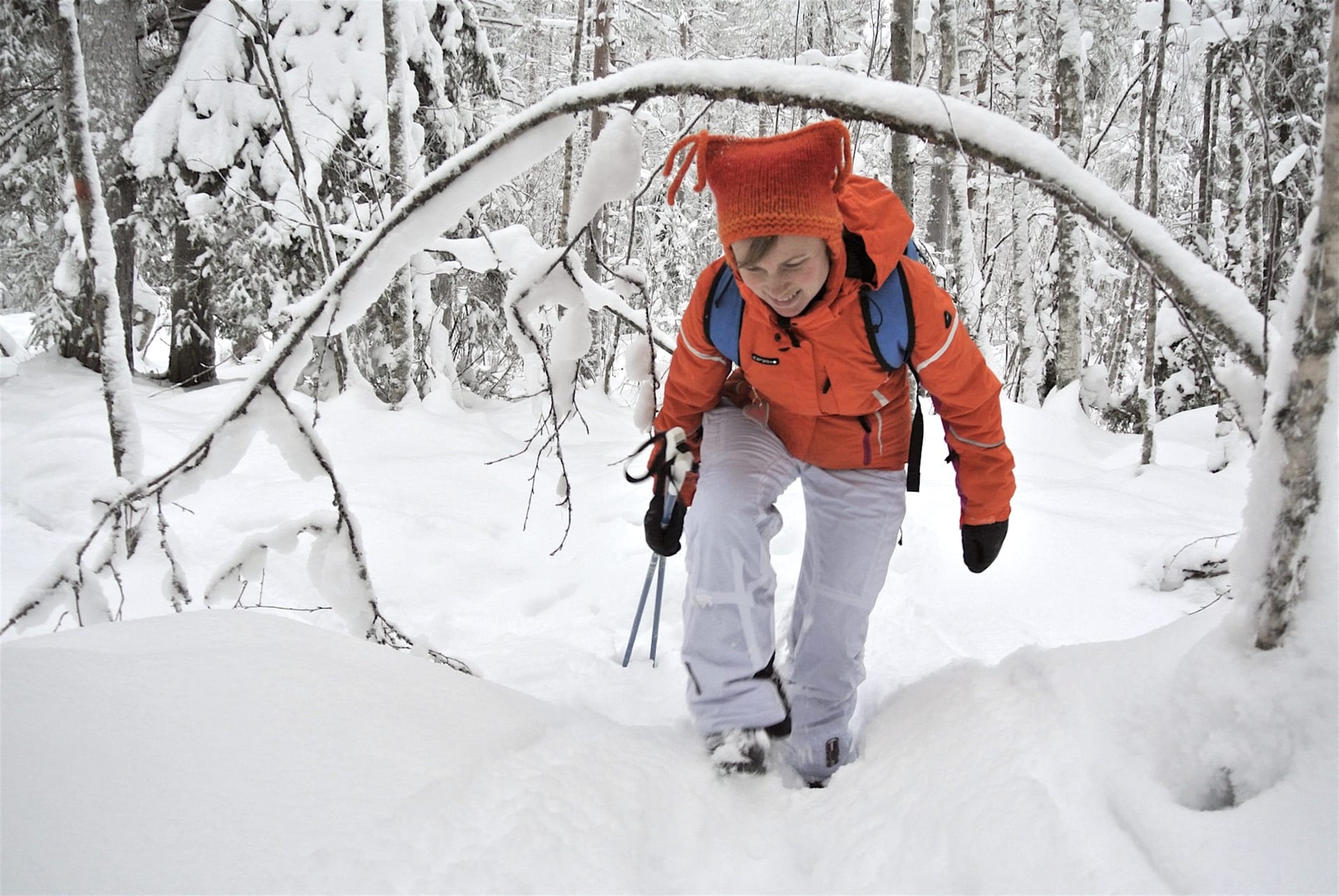 Woman walking in snow-covered forest in Finland.