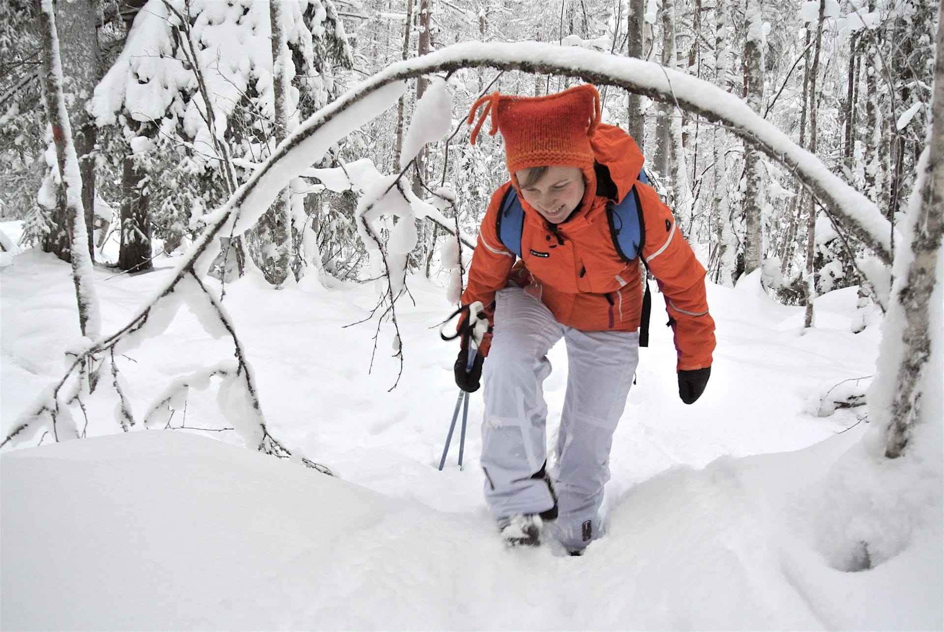 Woman walking in snow-covered forest in Finland. 