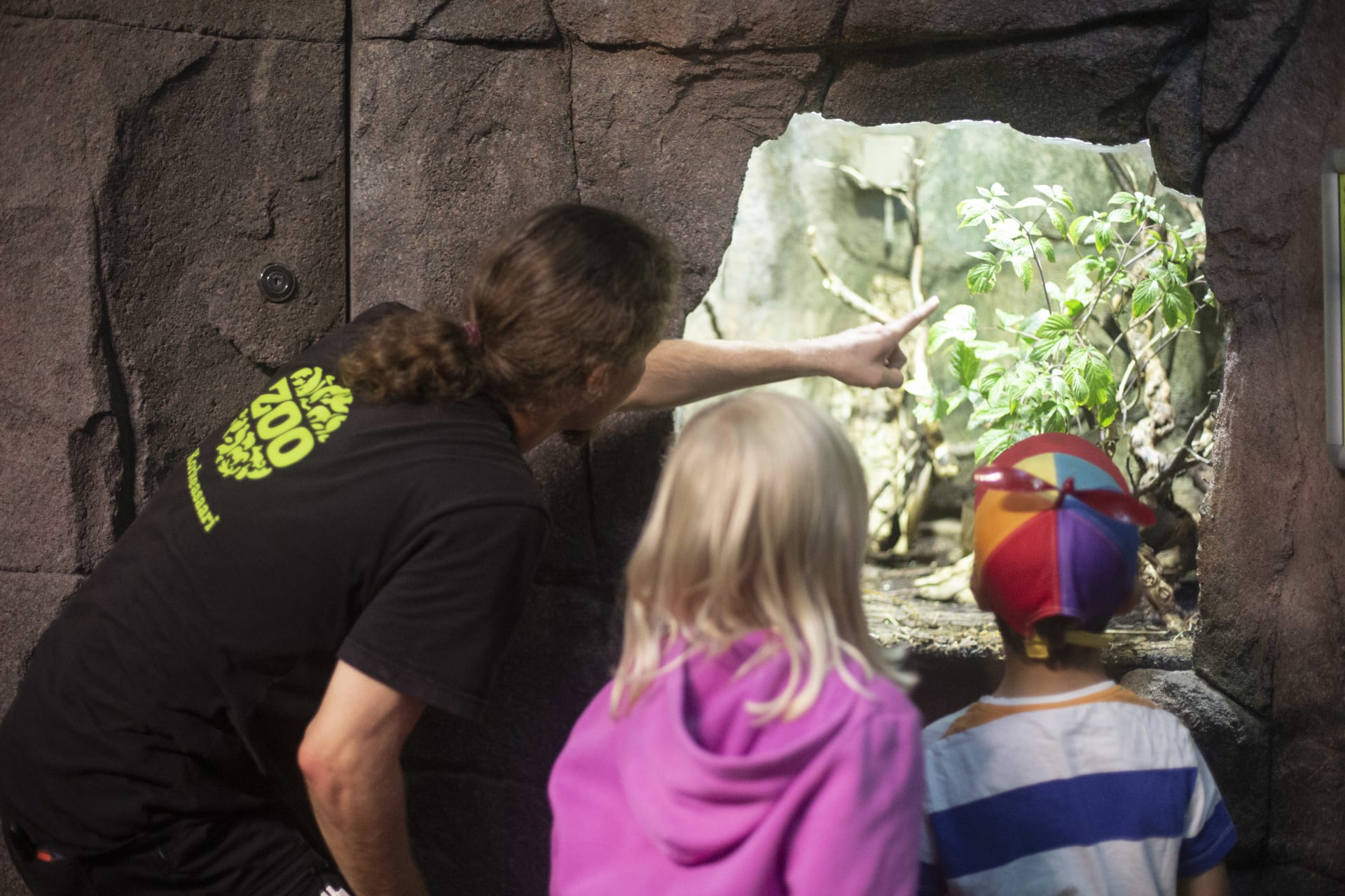 Zoo guide teaching kids in the tropical house