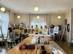 Ihmisiä maalausten kanssa.