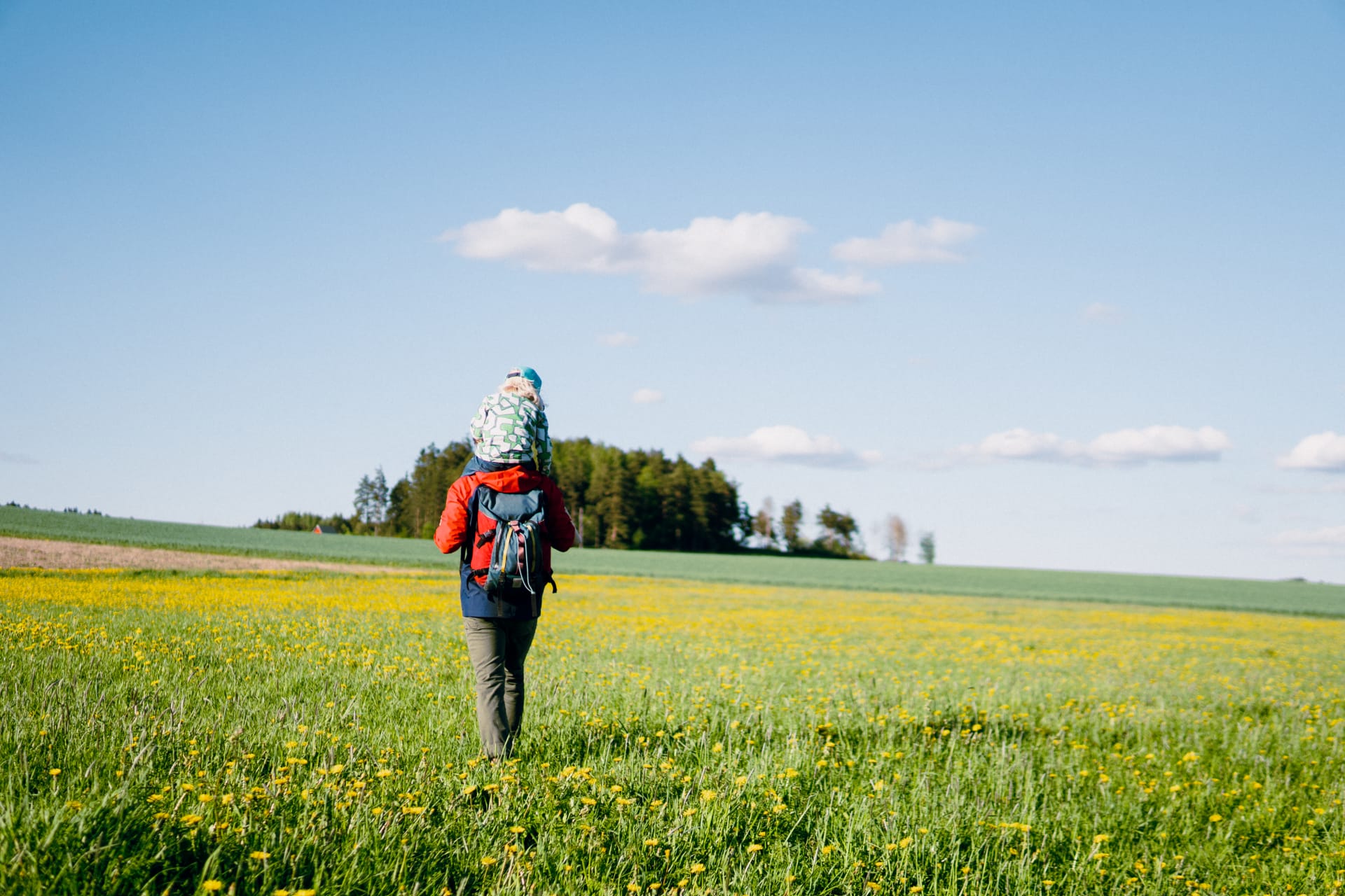 Mies kulkee rypsipellolla lapsi olalla. Mies kulkee rypsipellolla lapsi olalla.