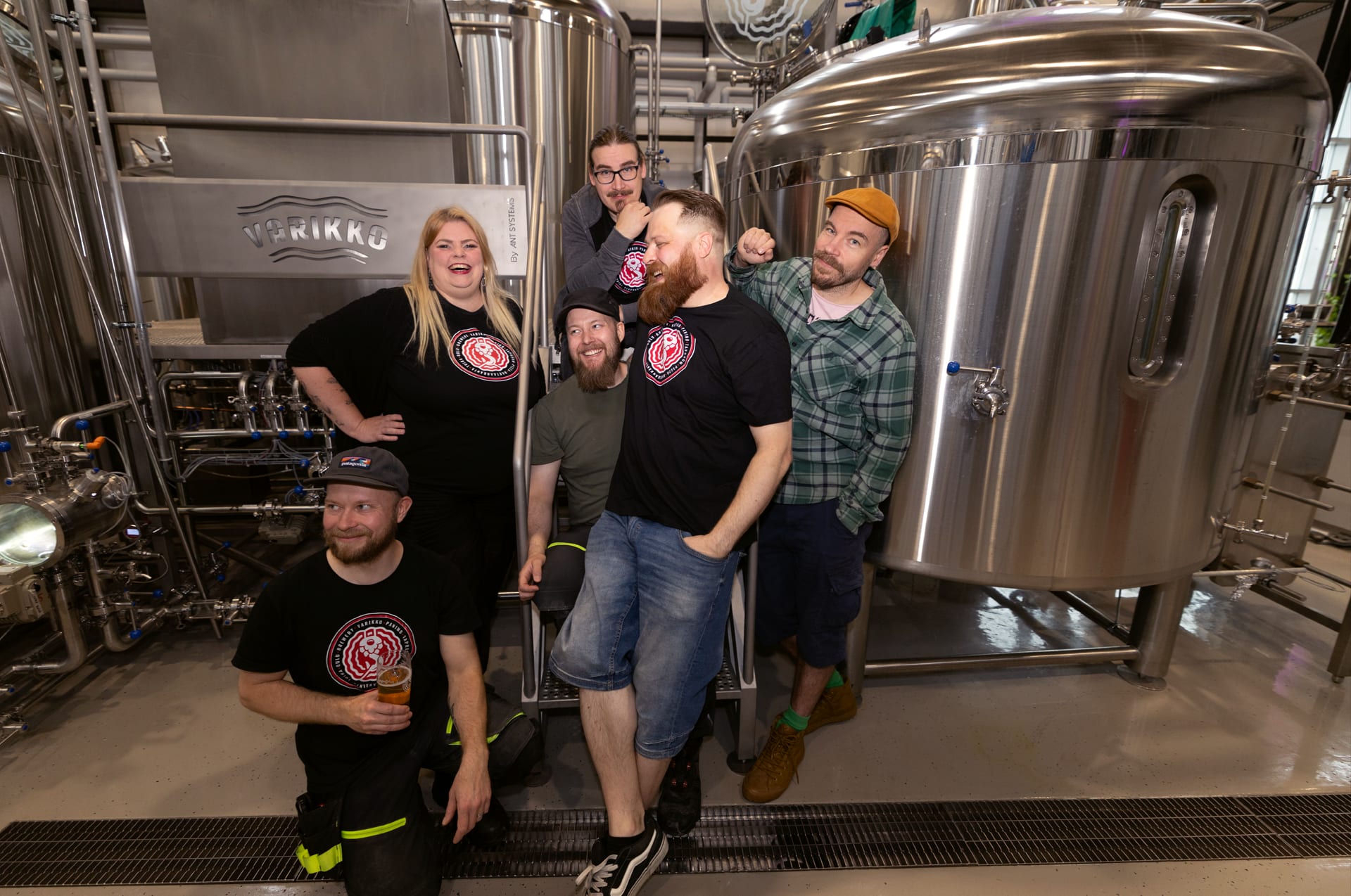 craft brewery people and modern brewing equipment and fermentation tanks.