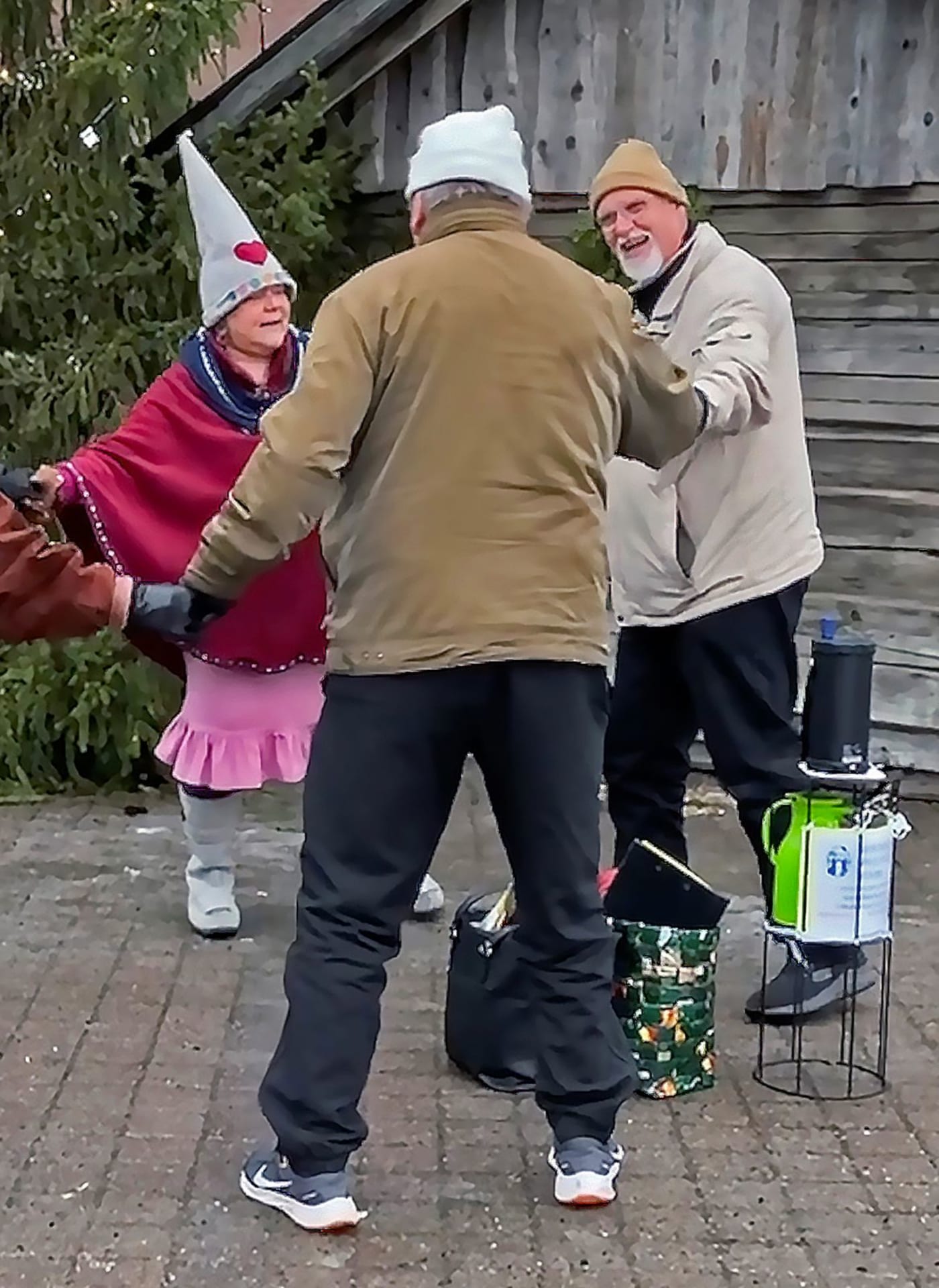 Good Will Elf dancing with two men at the Lordi's Square.