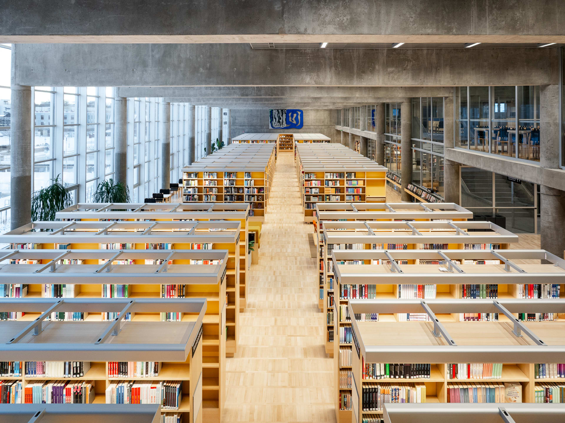 Korkea sali täynnä täysiä kirjahyllyjä.