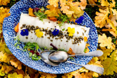 Food on blue plate with flowers and autumn leaves around.