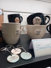 Ceramic cups and key rings with Oulu dialect