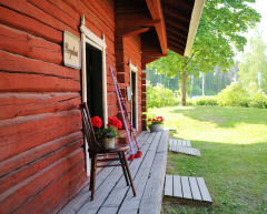 Aittarakennus ja kukkia tuolilla