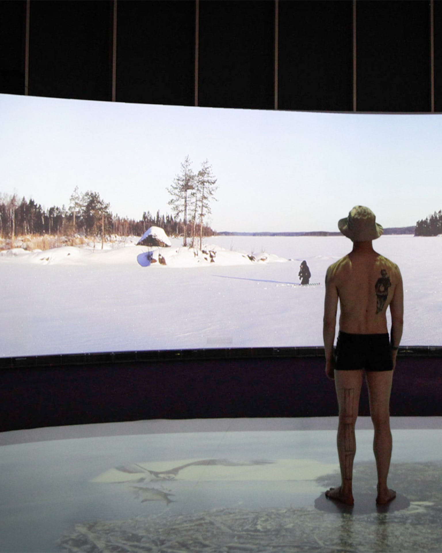 Ihminen kesävarusteissa katsoo talvimaisemaa