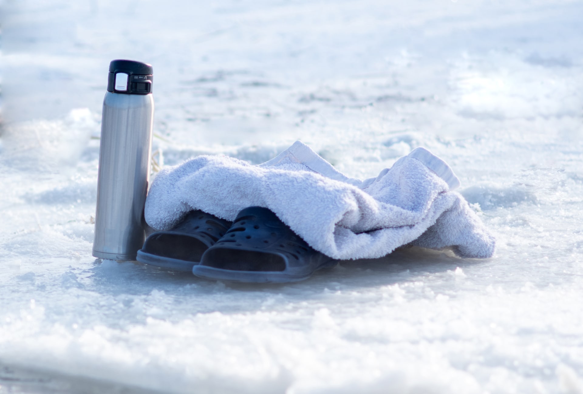 A drink, towel and flip flops at the edge of the ice