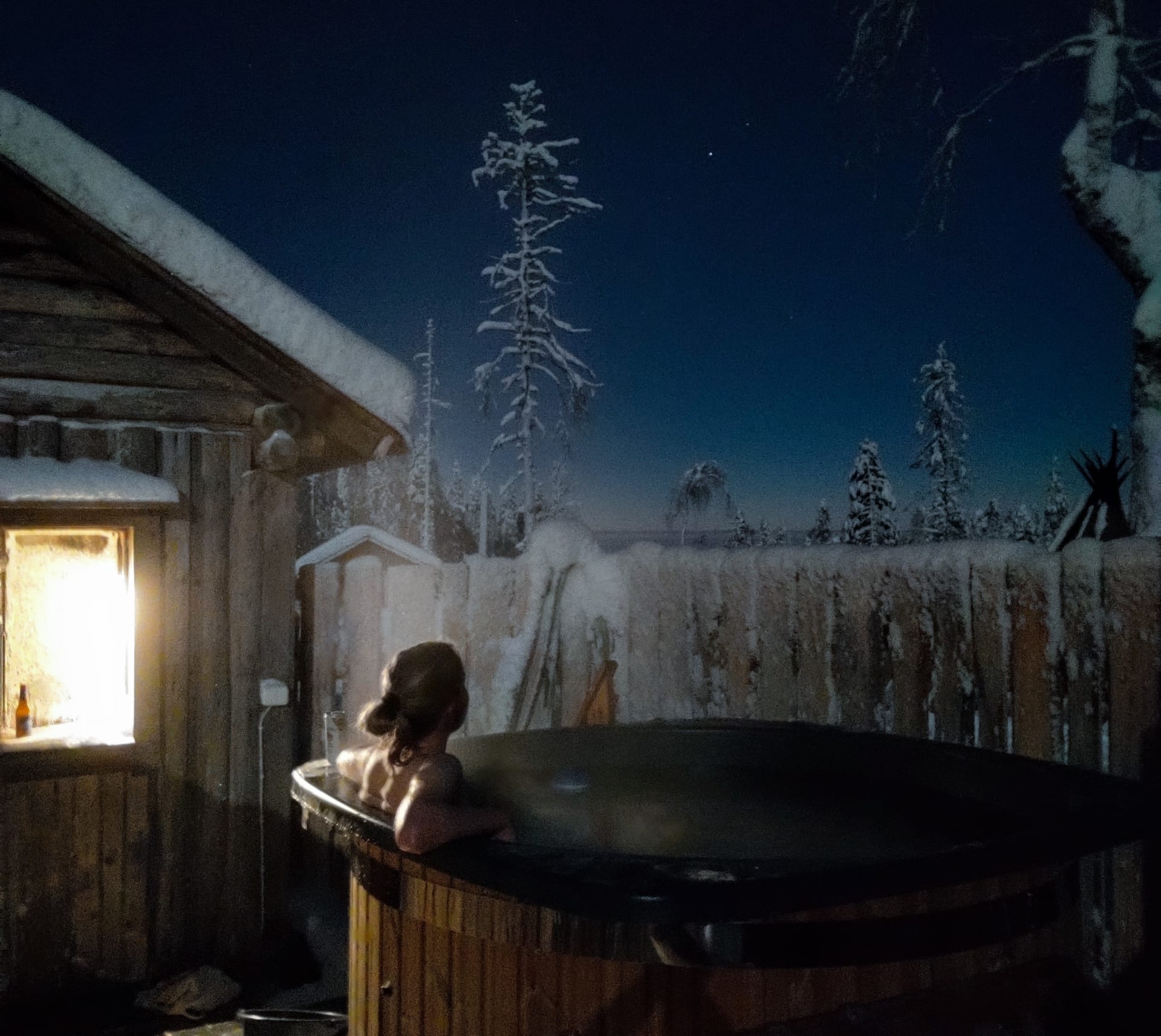 Woman in hot tub under a starry sky in Kotatieva