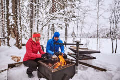 Mies ja nainen istuvat nuotiolla.