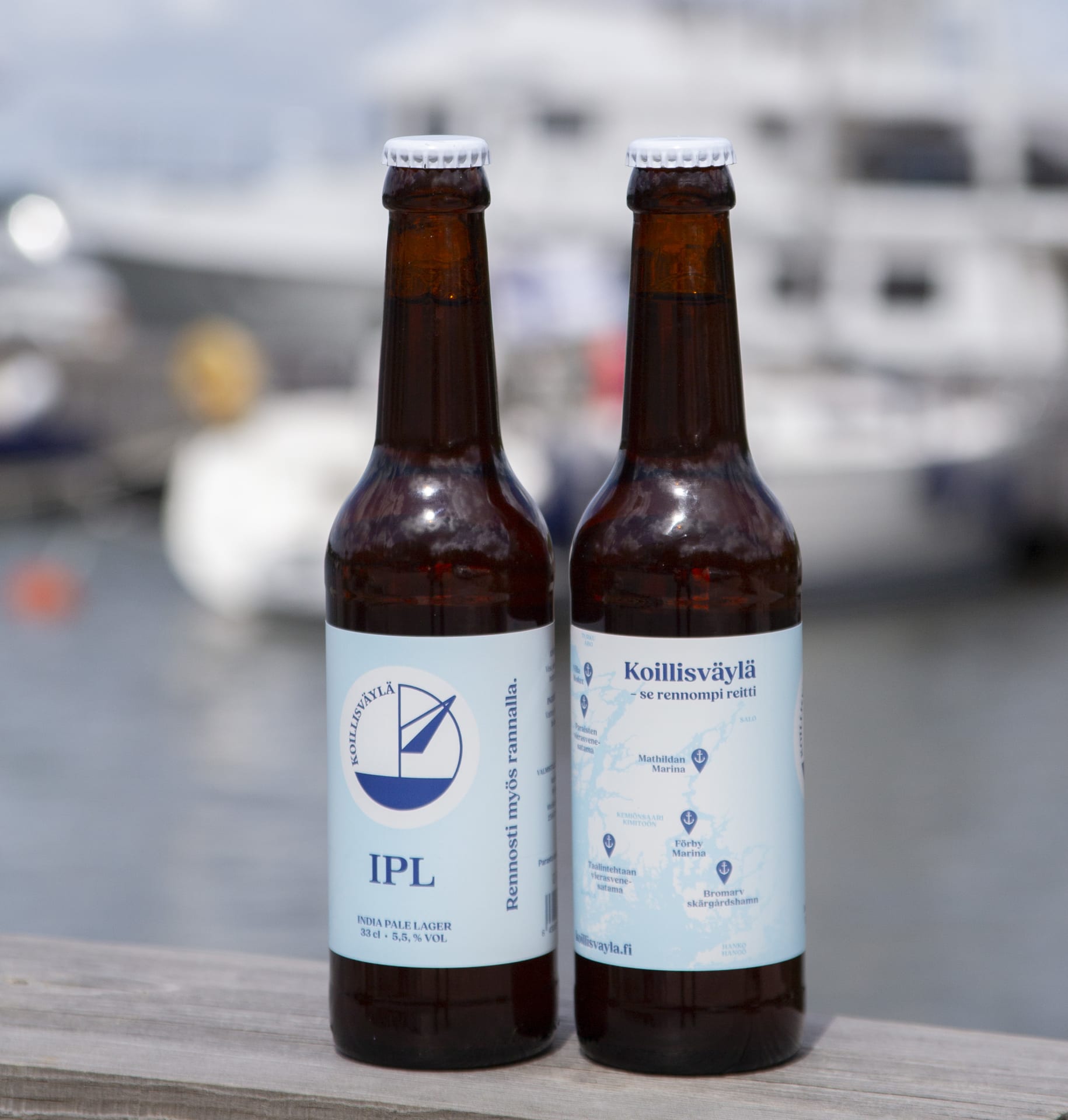 Two local beer bottles on the railing with the harbour view in the background.