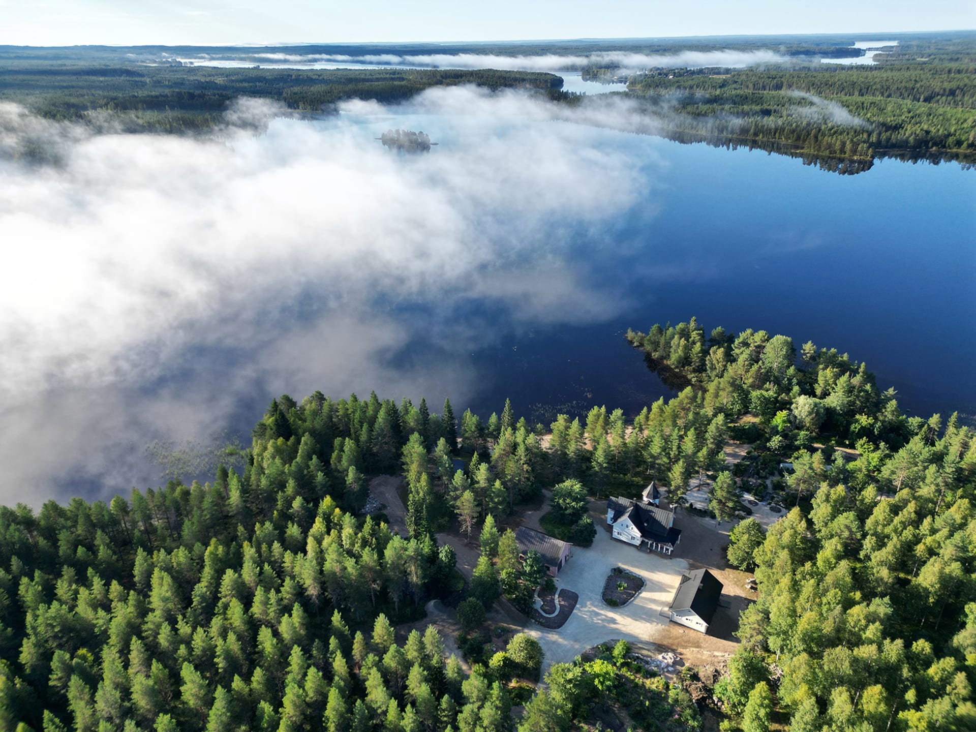 A bird’s-eye view of Villa Cone Beach and the private Lake Korpijärvi, showcasing the green wilderness and the place