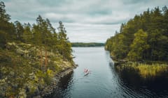 Two persons in a double kayak paddling in Linnansaari National Park on Lake Saimaa