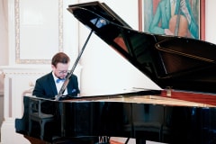 a man plays the grand piano
