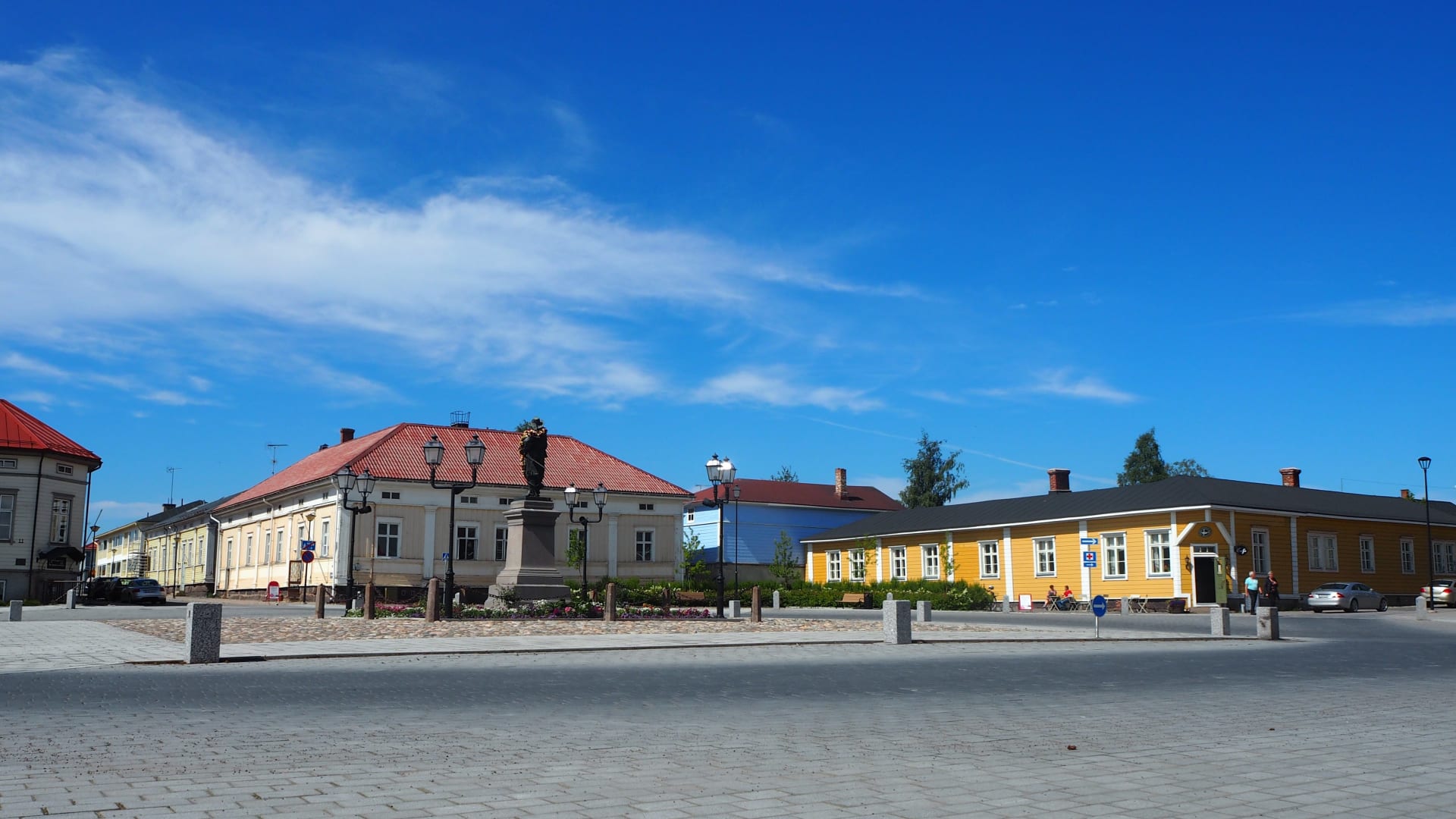 one corner of Pekkatori square with old wooden houses in white, yellow and blue