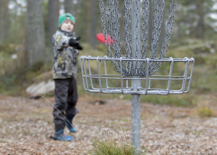 lapsi heittämässä frisbeegolfia Pyhäjoella