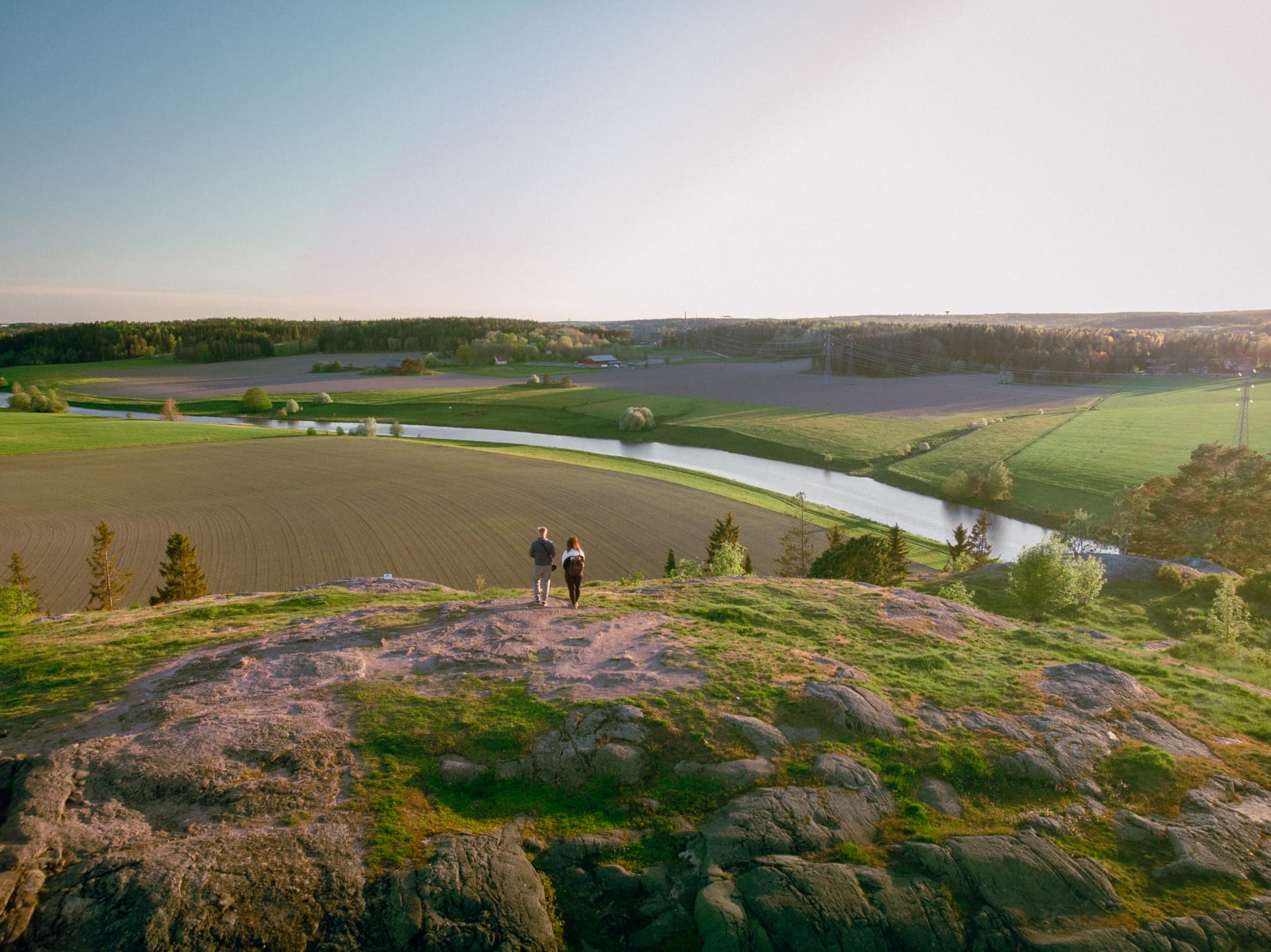 Kaksi ihmistä seisoo Liedon vanhalinnan kukkulalla Kaksi ihmistä seisoo Liedon vanhalinnan kukkulalla