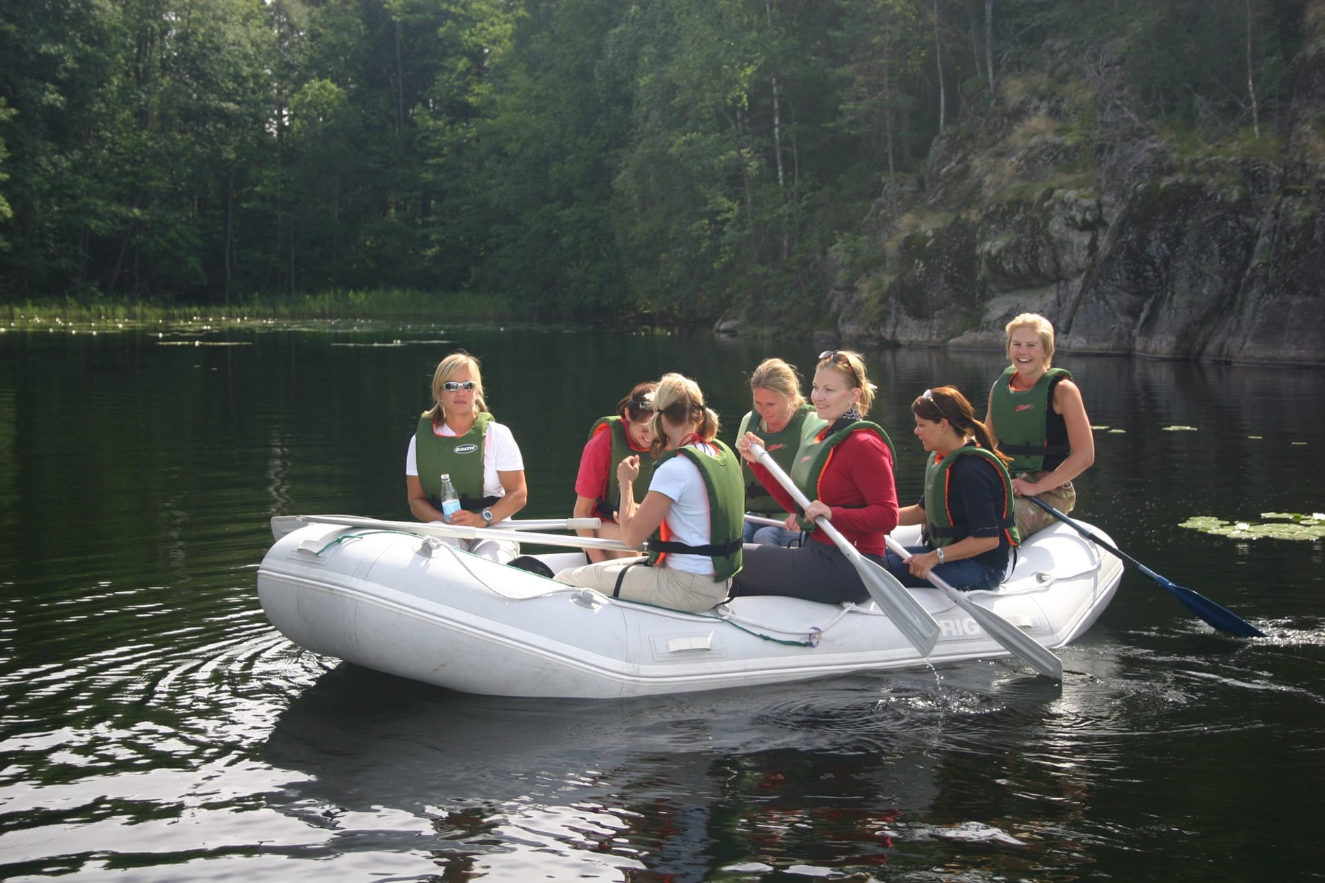 Seven persons raft on a beautiful lake