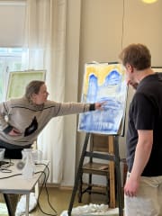 Ihmisiä maalauksen edessä.