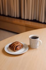 Kuppi mustaa kahvia ja perinteinen suomalainen korvapuusti.