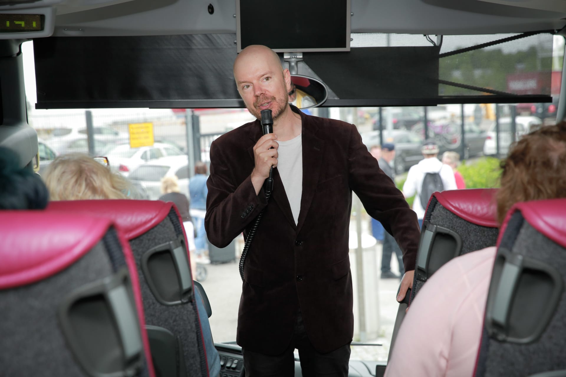 Guide talking to a microphone inside a tour coach