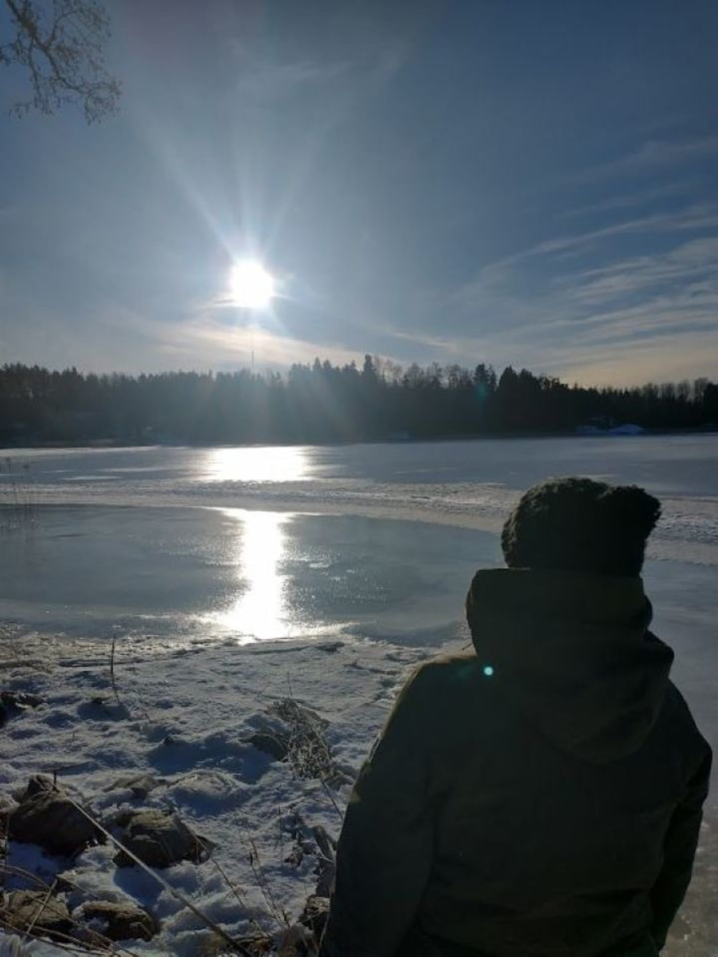 A woman watches the winter sun