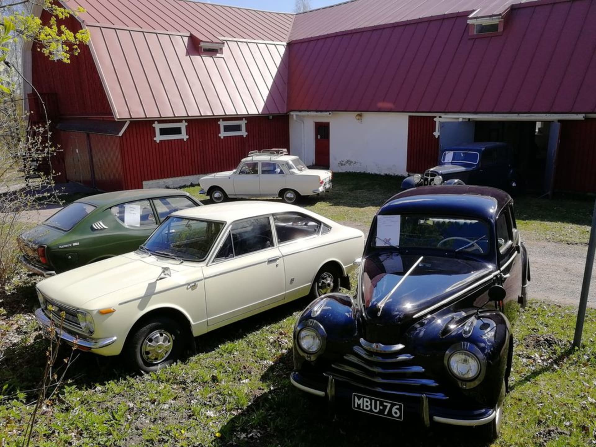 Vanhoja autoja rivissä vihreällä nurmikolla