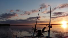 Spinning rods on a sunset in the boat and middle of a lake